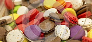 Lots of colorful macaroons on the counter in a store. Delicious sweet cookies for coffee. Close-up