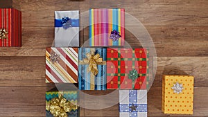 Lots of colorful wrapped presents gather on wooden surface