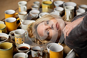 Lots of cups of coffee and a tired woman. Deadline, overtime concept. Need for wakefulness.