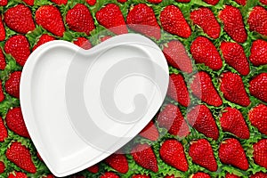 Lots of delicious ripe red strawberries laid out in rows. White empty plate in the shape of a heart on a strawberry background