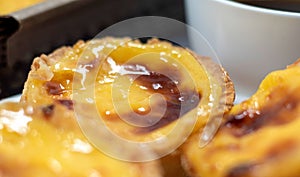 Lots of desserts Pastel de nata or Portuguese egg tart with a white cup of black coffee. Pastel de Belm is a small pie