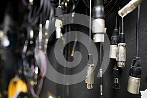 Lots of different audio and internet cables in a dark studio room