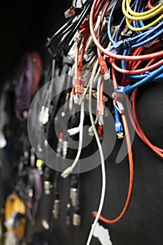 Lots of different audio and internet cables in a dark studio room