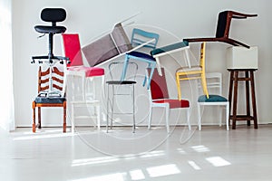 Lots of different chairs in the interior of an empty white room