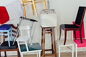 Lots of different chairs in the interior of an empty white room