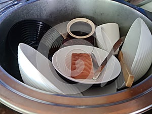 Lots of dirty dishes in sink. Dishwashing closeup