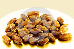 Lots of dried medjool dates on a shiny gold plate