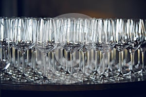 Lots of empty wine glasses on the bar, close up. Restaurant serving.