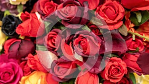 Lots of fake flowers artificial red roses fake plants made of fabric at the store, faking reality and nature simple abstract photo