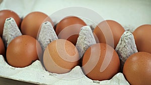 Lots of fresh raw chicken eggs in cardboard boxes. Chicken brown fresh raw eggs in an egg container.