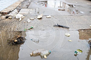 Lots of garbage,littering,many old plastic bottles float on the water surface after heavy rain and flooding,waste and dirt rubbish