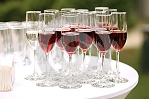 Lots of glass goblets with red wine at a party, great red wine outdoors