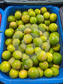 Lots of green limes in the blue container.