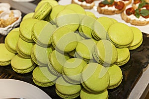 Lots of green macarons on the buffet table. Holiday breakfasts and coffee breaks. Close-up