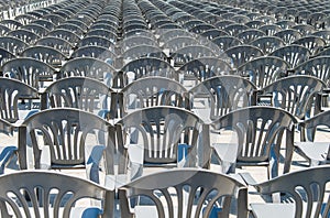 Lots of grey plastic chairs in the row