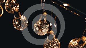 Lots Hanging Glowing Vintage Edison Light Bulbs on Black Background