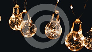 Lots Hanging Glowing Vintage Edison Light Bulbs on Black Background