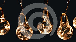Lots Hanging Glowing Vintage Edison Light Bulbs on Black Background