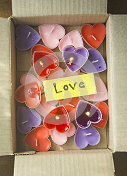 Lots of heart-shaped candles are in the parcel box on Valentine`s Day.