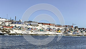 Lots of Inuit huts and colorful houses situated on the rocky coast along the fjord, Nuuk city, Greenland