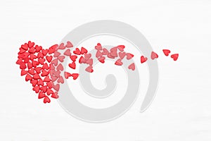 Lots of little red hearts flying on white background.