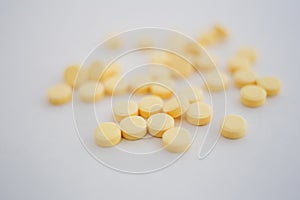 Lots of little yellow pills on white background