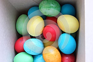 Lots of multi-colored Easter eggs in a white square box. Easter preparations. Painting eggs