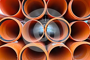 Lots of new orange sewer pipes with gaskets, 100mm photo