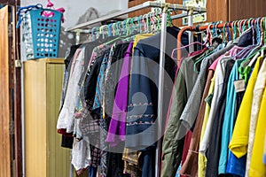 Lots of old, colorful clothes hung chaotically on the iron railings near the closets