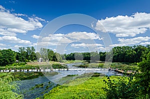 Lots of people cross the Venta waterfall - the widest waterfall in Europe, Kuldiga, Latvia