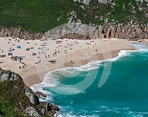 Lots of people swimming and sunbathing at Porthcurno Beach