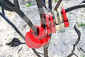 Lots of red and golden heart-shaped locks hanging on a metal tree