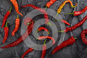 Lots of red hot chili pepper on natural black stone background