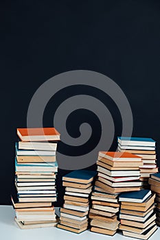 Lots of stacks of old educational books on black background library