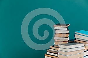 Lots of stacks of old books on green background, school library