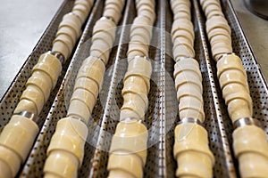 Lots of sweet rolls of raw puff pastry on a metal cone. Baking in a pastry shop. View from above
