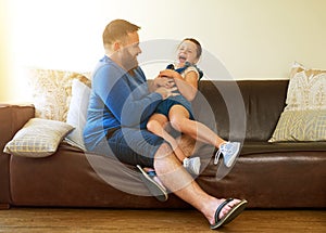 Lots of tickles and a whole lotta giggles. an adorable little girl getting tickled by her father at home. photo