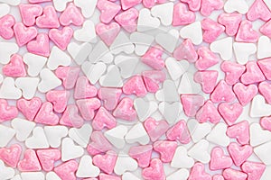 Lots of white and pink sugar hearts on white background