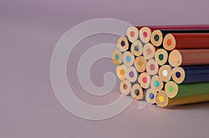 Lots of wooden coloured pencils isolated on the pink background