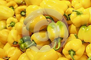 Lots of yellow bell peppers on the counter. Healthy foods and vegetarianism. Close-up. Background