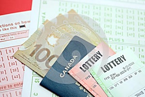 Lottery tickets lies with canadian dollars on gambling sheets with numbers for marking to play lottery