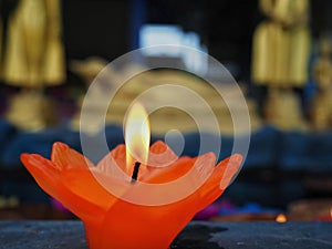 A lotus flower candle with light for pray to Buddha. First light the candle, second pray, and third put candle flower into water.