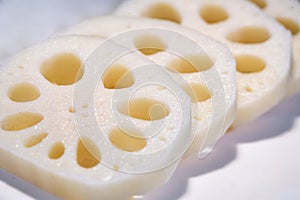 Lotus roots sliced on the white plate, Close-up with shallow depth of field