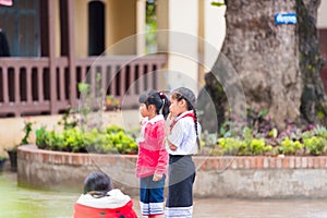 LOUANGPHABANG, LAOS - JANUARY 11, 2017: Children in the school yard. Copy space for text. Close-up.