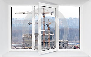 Loud construction site noise immission in opened one frame of pvc window, view through