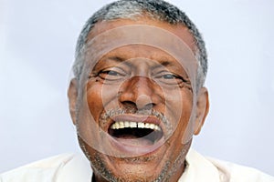 Loud laughing open mouth of a Indian senior man on white background.