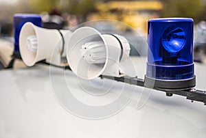 Loudspeaker and blue lights on top of police car