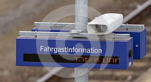 Loudspeaker, digital clock and information board with the German inscription, translation: