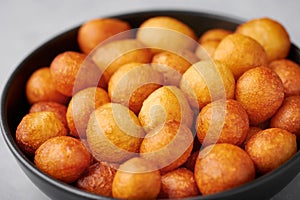 Loukoumades or luqaimat or lokma in black bowl. Popular Ramadan or Ramazan Food. Iftar or Suhur sweets photo