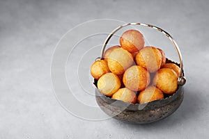 Loukoumades or luqaimat or lokma in metallic bowl. Popular Ramadan or Ramazan Food. Iftar or Suhur sweets photo